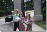 Three Happy Helpers passing out bulletins for the event.